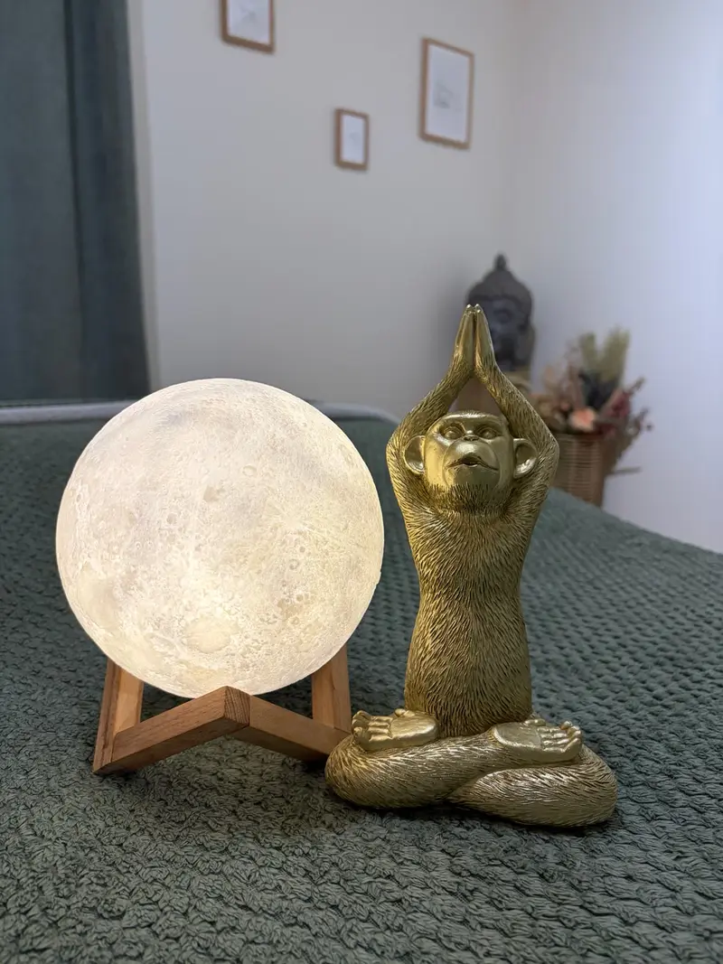 Lampe lune et statuette dorée posées sur la table de massage