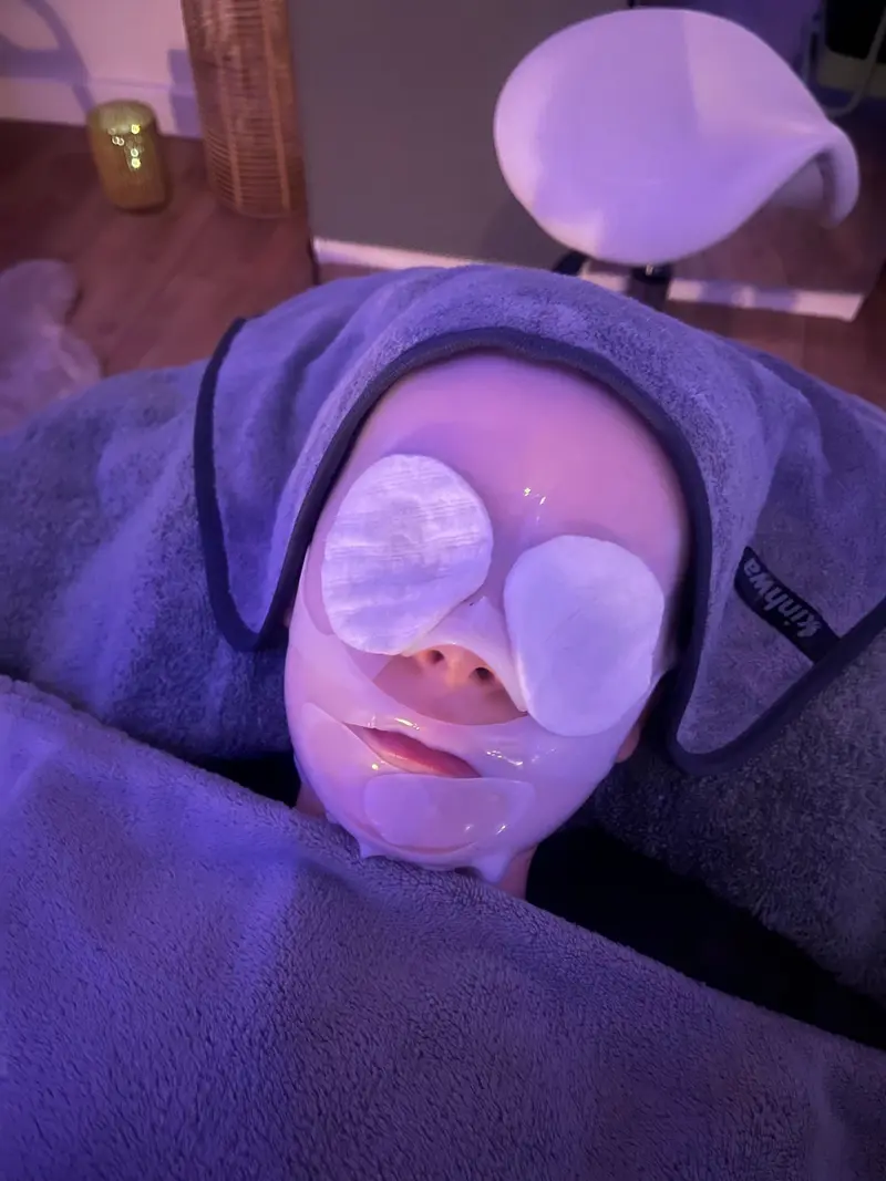 Cliente pendant un soin du visage, compresses sur les yeux